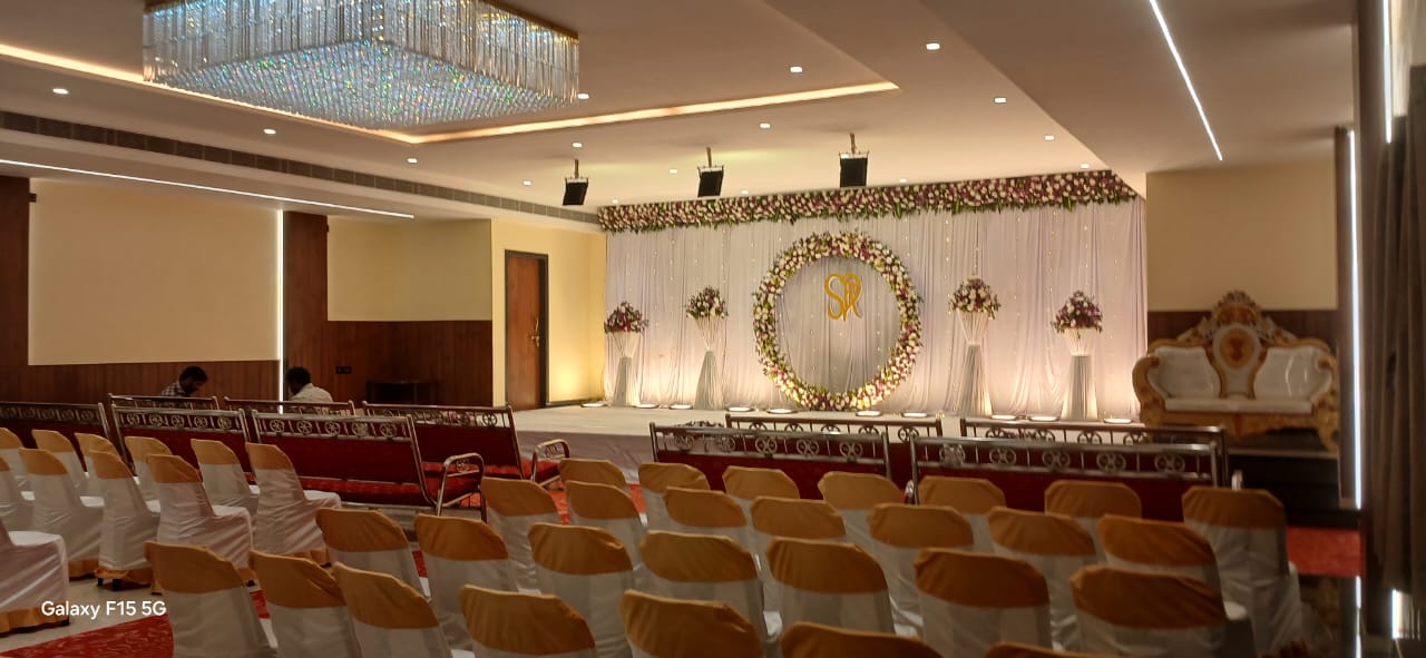 Hall interior with chandelier, floral ring stage and seating rows