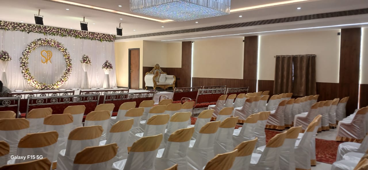 Wide view of the hall with stage backdrop and guest seating