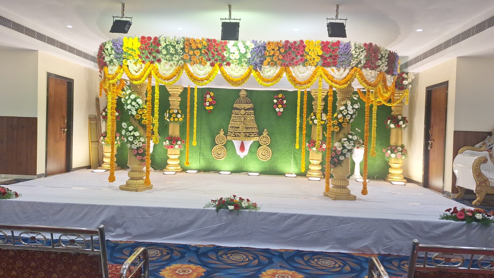 Golden pillared wedding mandap with marigold and mixed floral canopy