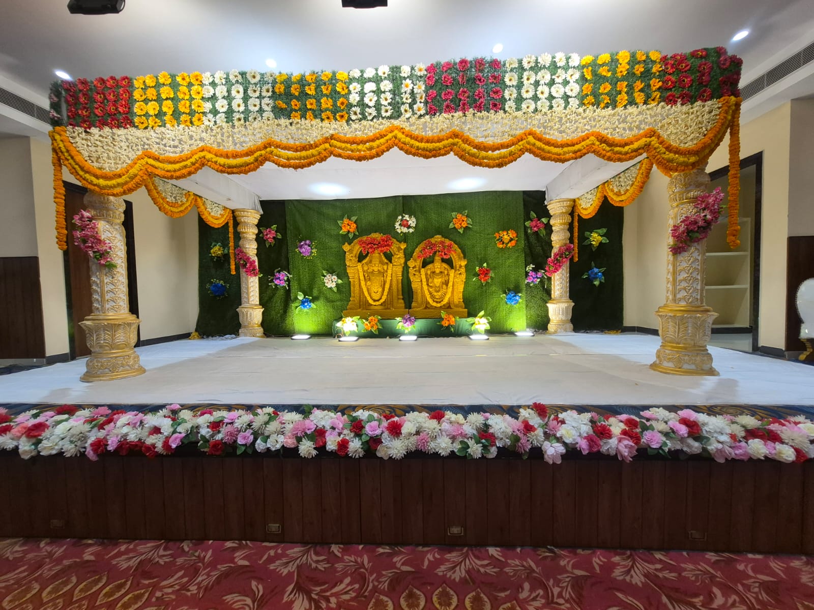 Traditional wedding stage with marigold garlands and carved pillars